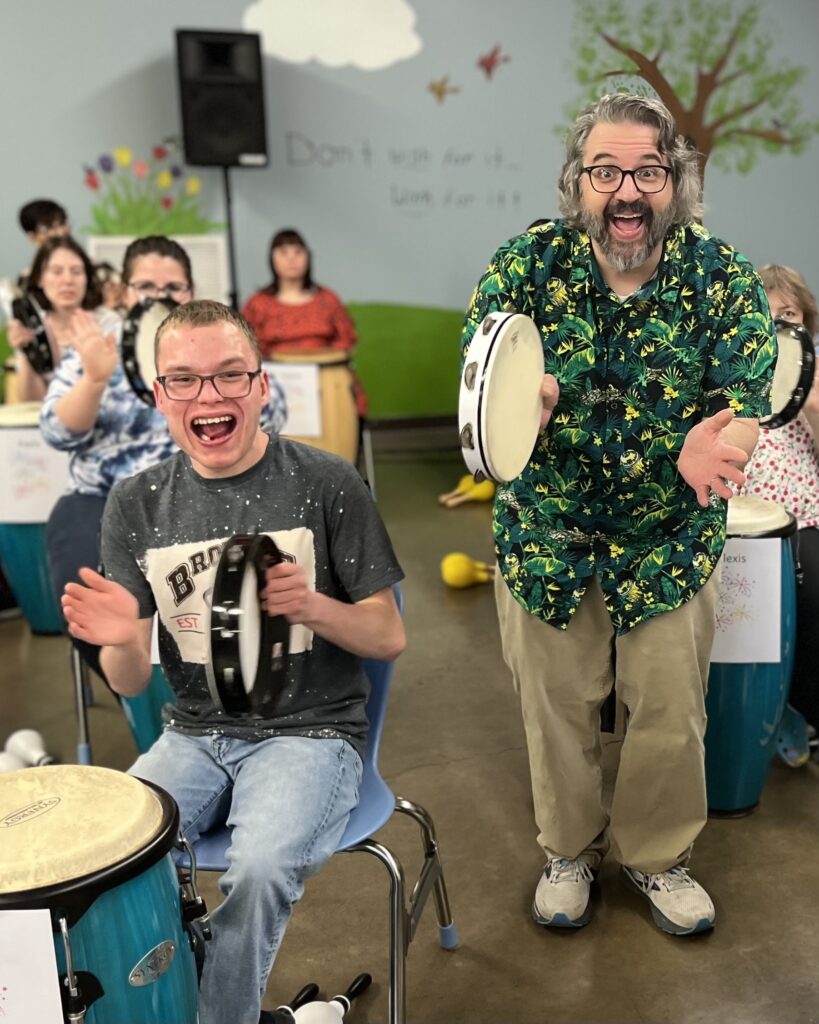 Jim Howell and student playing the tambourine.
